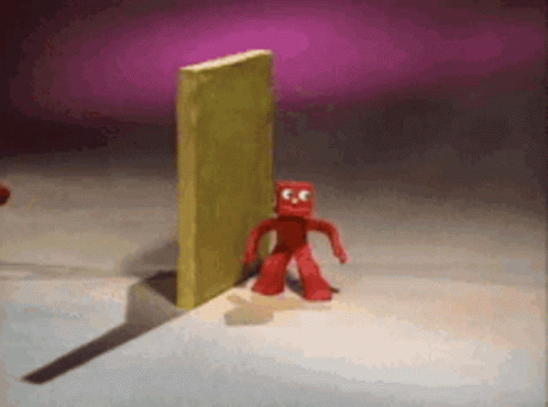 Red Cartoon Character in Front of Yellow Wall