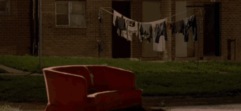 Red Couch by Brick Building with Clothes Line