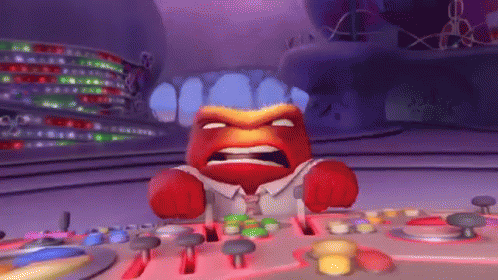 Red-Faced Cartoon Character at Table With Buttons