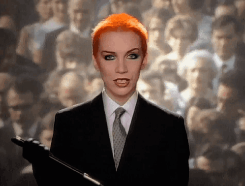 Red Hair Woman In Suit Holding Microphone GIF
