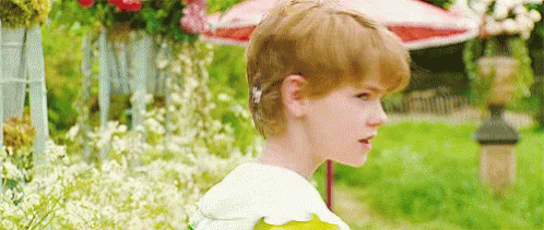Red-Haired Boy With Flower In Garden GIF