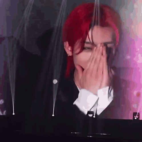 Red-Haired Man Covering Face at Piano
