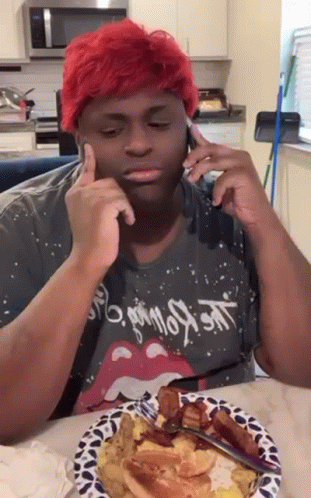 Red-Haired Man Sitting at Table With Food and Cell Phone