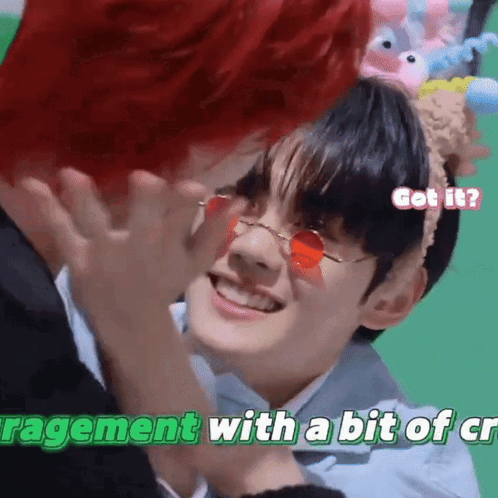 Red-Haired Man Touching Another's Face With Red Sunglasses and Headband