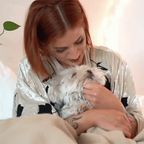 Red Haired Woman Petting Small White Dog