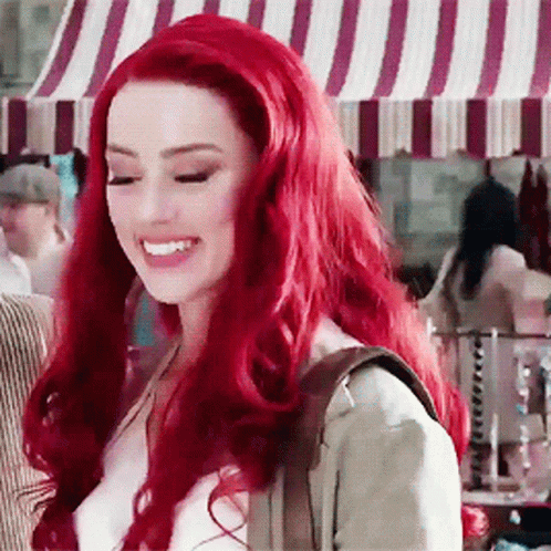 Red-Haired Woman Smiling at Striped Canopy