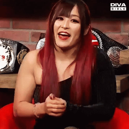 Red-Haired Woman Smiling With Diva Bible Championship Belts