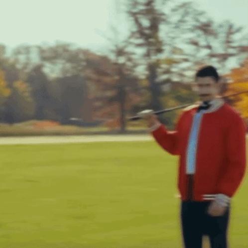 Red Jacket Man Holding Sword in Field