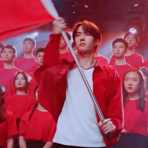 Red Jacket Man Holds Red Flag Before Crowd