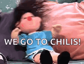 Red Nose Doll Laying on Pillow Saying We Go to Chilis