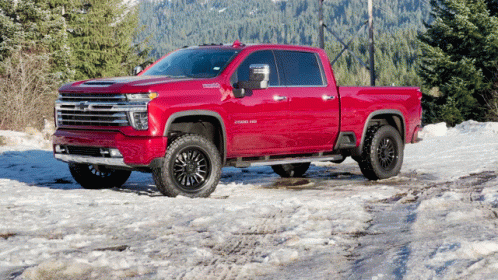 Red Pickup Truck Parked in Snow with Trees