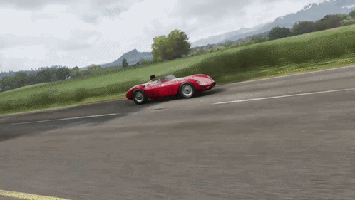 Red Race Car Driving Down Mountain Road