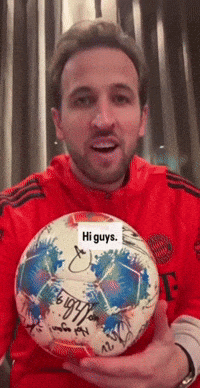 Red Shirt Man Holding Signed Soccer Ball Saying Hi Guys