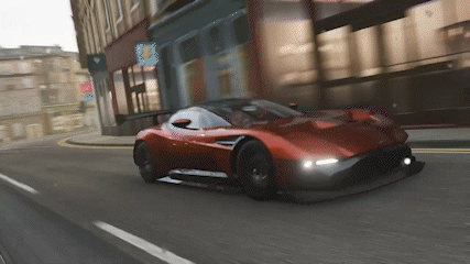 Red Sports Car Driving Down City Street