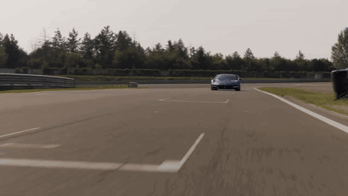 Red Sports Car Driving Down Road With White Line