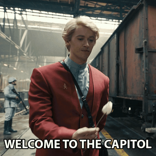 Red Suit Man Holds Flower Welcome To Capitol GIF