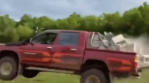 Red Truck Driving On Grassy Field GIF
