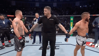 Referee Between Two Men in Boxing Ring