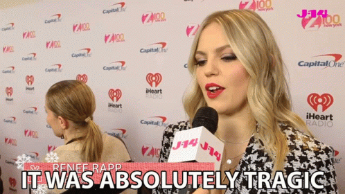 Renee Rapp Says It Was Absolutely Tragic In Front Of A Wall Of Iheart Radio Logos GIF