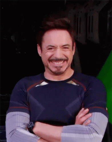 Robert Downey Jr. Is Smiling With His Arms Crossed In Front Of A Green Screen GIF
