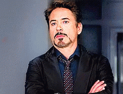 Robert Downey Jr. Is Wearing A Suit And Tie And Has His Arms Crossed . GIF