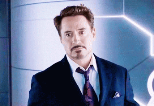 Robert Downey Jr. Is Wearing A Suit And Tie And Looking At The Camera . GIF