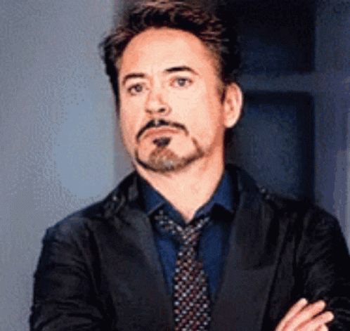 Robert Downey Jr. Is Wearing A Suit And Tie And Making A Funny Face . GIF