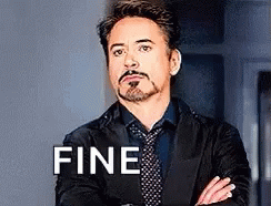 Robert Downey Jr. Is Wearing A Suit And Tie With His Arms Crossed And The Word Fine On His Chest . GIF