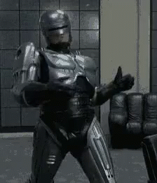 Robot in Suit Giving Thumbs Up in Living Room