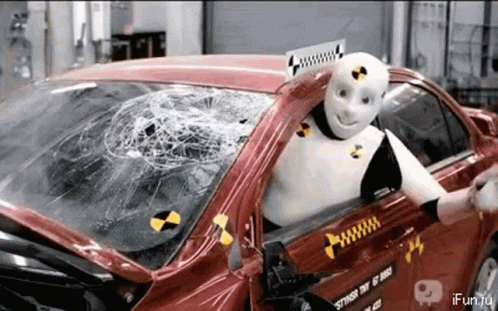 Robot Sitting In Car With Smashed Windshield GIF