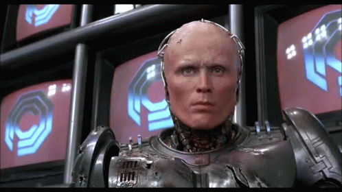 Robot Standing in Front of Monitors With O