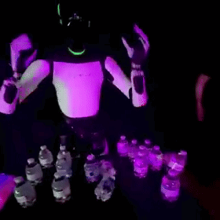 Robot Standing in Front of Table Full of Water Bottles
