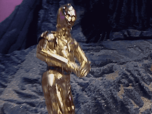 Robot Statue Covered in Gold Powder Purple Background