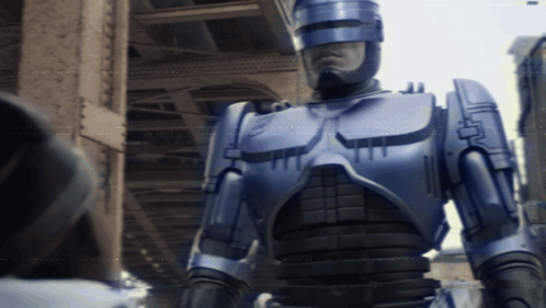 Robot With Helmet in Front of Building