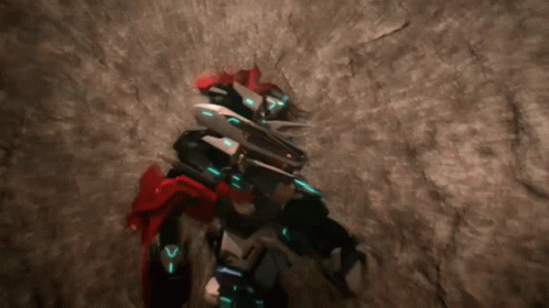Robot With Letter V on Chest Standing in Cave