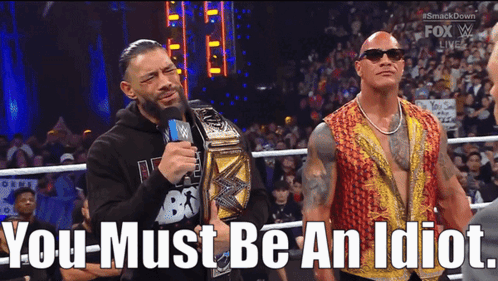 Roman Reigns And The Rock Are Standing Next To Each Other In A Wrestling Ring With The Words You Must Be An Idiot Below GIF