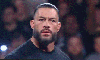 Roman Reigns Is Standing In Front Of A Crowd Wearing A Black Shirt . GIF