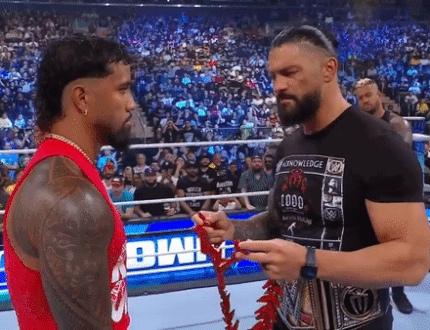 Roman Reigns Passing Garland To Jey Uso GIF