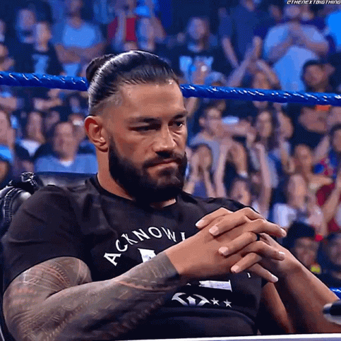 Roman Reigns Sitting In Chair With Hands Folded GIF