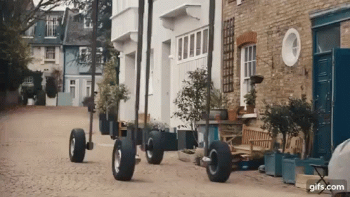 Row of Houses on Cobblestone Street With Large Wheels