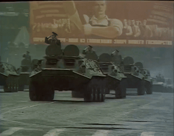 Row of Military Vehicles in Front of Russia Billboard