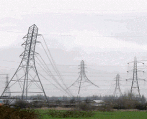 Row Of Power Lines Through A Field GIF