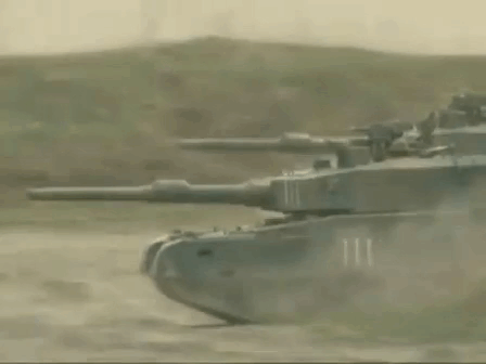 Row of Tanks Driving Down Dirt Road
