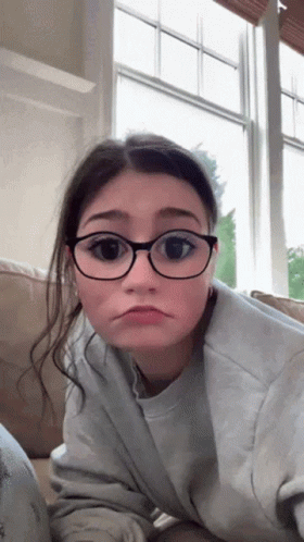 Sad Girl With Glasses Laying on Couch