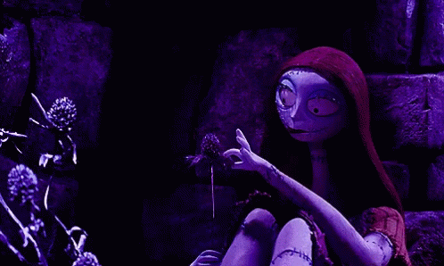Sally From The Nightmare Before Christmas Is Holding A Flower In Her Hands . GIF