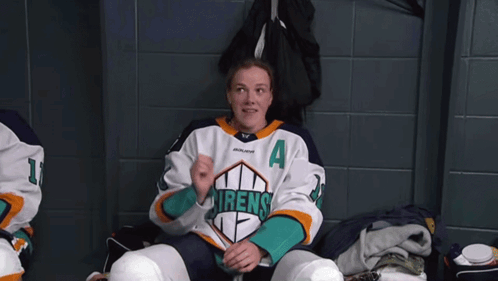 Sarah Fillier Sits In A Locker Room With Her Arms Outstretched GIF