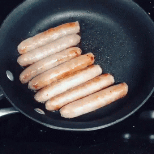 Sausages Are Cooking In A Frying Pan On The Stove GIF