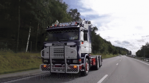 Scania Truck Driving Down Highway With Trees