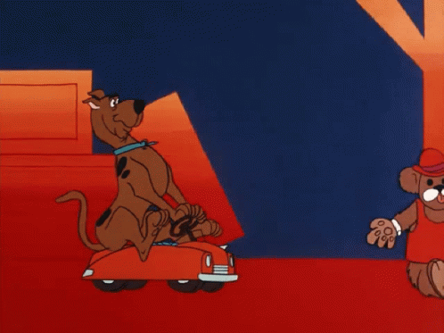 scooby doo is carrying a stack of boxes in a red car
