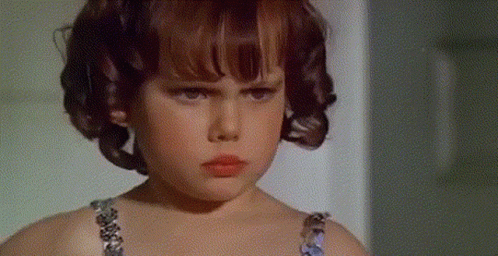 Serious Young Girl With Curly Hair Looking at Camera